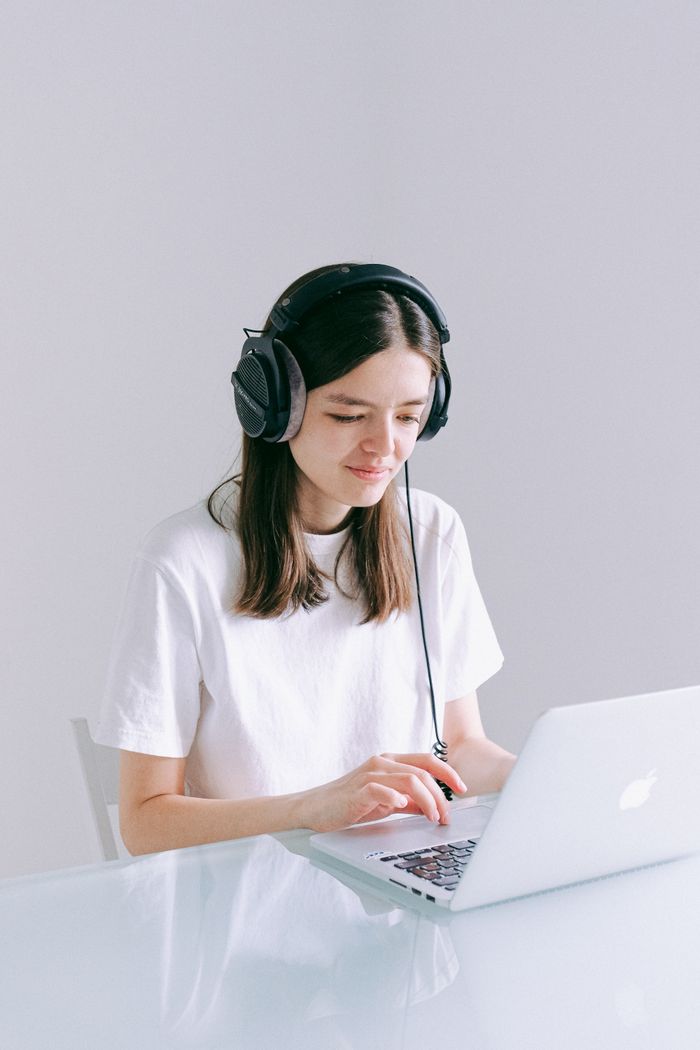 Young woman in headphones working from home on laptop. Ideal for remote work and technology themes.